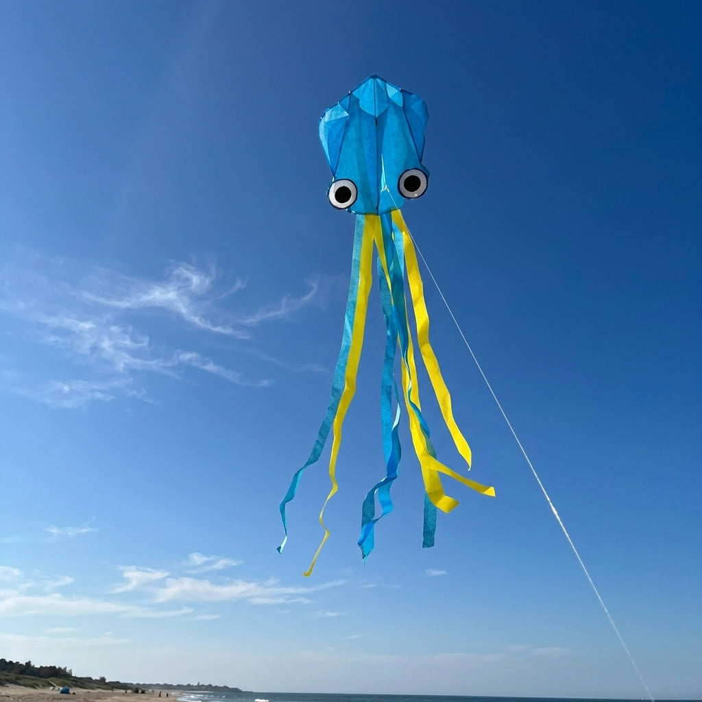 Wikz Blæksprutte drage i blå med lange haler, vist mod himlen